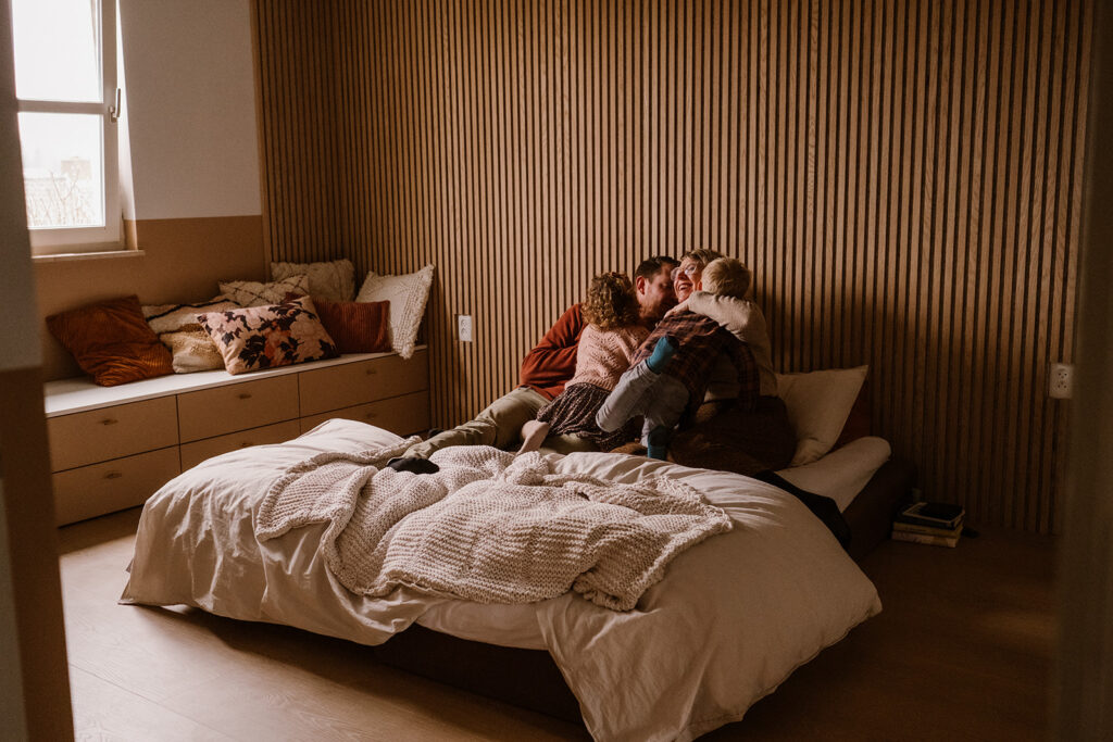 Gezin knuffelt op bed in eigen huis in Limburg