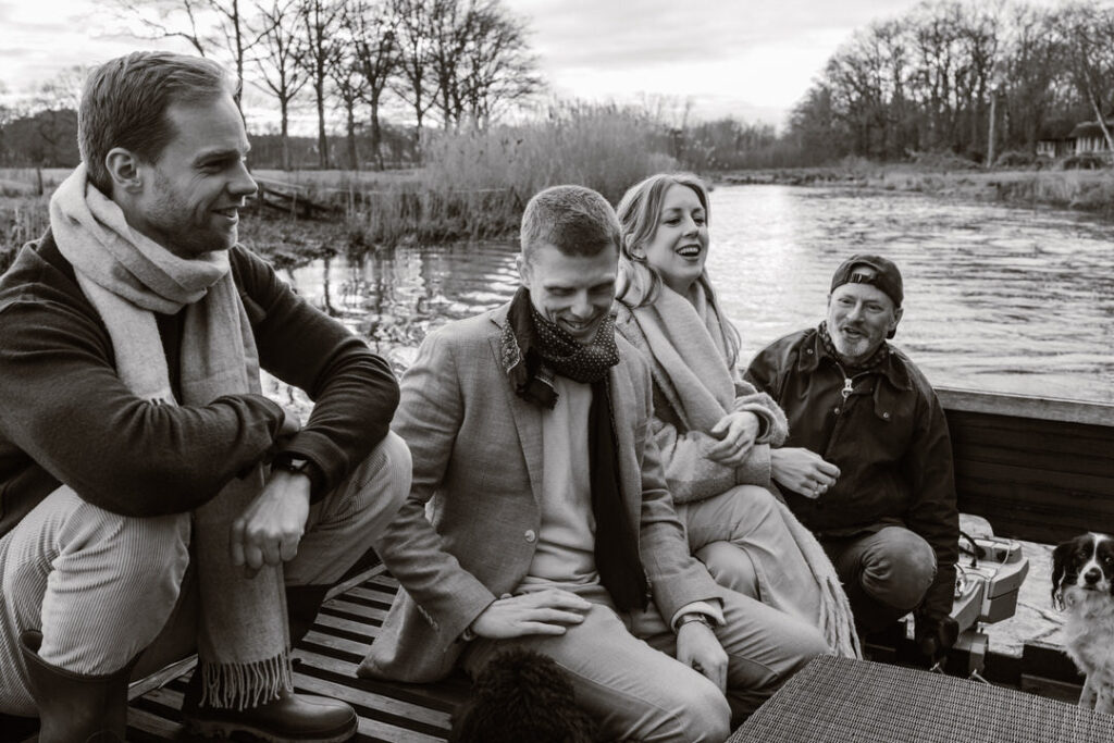 Mensen varen op een vlot op de Regge in Ommen en lachen met elkaar