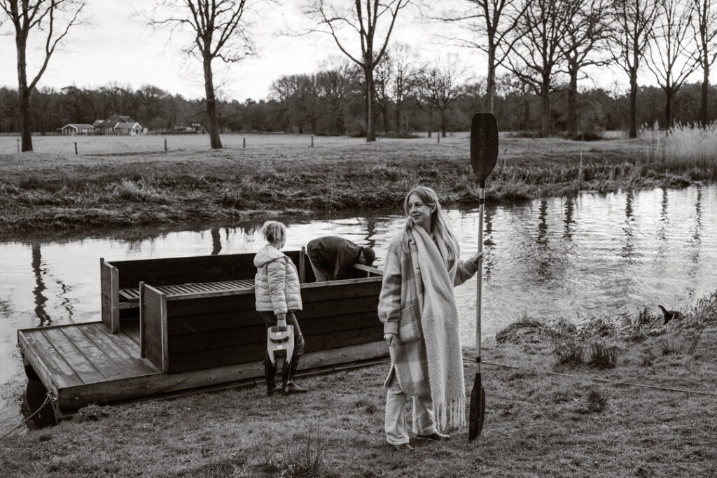 Vrouw met peddel en haar hand met op de achtergrond een vlot en haar stiefmoeder